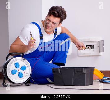 The funny man doing electrical repairs at home Stock Photo