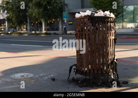 Seattle, USA. 26th Jun, 2021. As sweltering heat envelops Seattle, a previously burned garbage can sits by the South Lake Union Park. A metaphor as the PNW is in the midst of a heat wave. The Puget sound set a three-digit record today. Credit: James Anderson/Alamy Live News Stock Photo