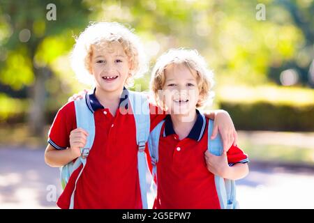 Children go back to school. Start of new school year after summer vacation. Boy and girl with backpack and books on first school day. New beginning Stock Photo