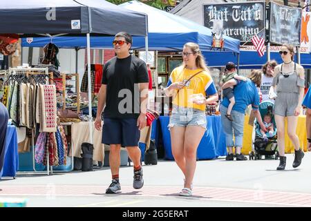 Danville, United States. 26th June, 2021. People walk past craft vendor booths during Danville Business Alliance's 35th Annual Spring Fling street festival.The event is usually held on the first Saturday in May but organizers rescheduled it for late June due to Centers for Disease Control and Prevention and Pennsylvania Department of Health pandemic guidelines. Credit: SOPA Images Limited/Alamy Live News Stock Photo
