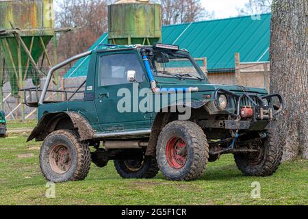 Gulbene, Latvia - May 02, 2021: Compact Japanese SUV Suzuki with off-road tuning in a farmyard Stock Photo