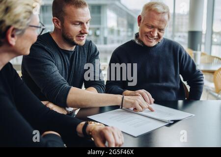 Young businessman reading agreement document during meeting. business team discussing the terms on contract document. Stock Photo