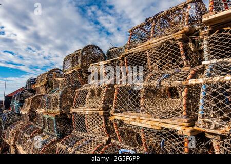 Fishing creels piled up on a harbour side in Scotland Stock Photo