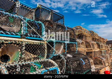 Fishing creels piled up on a harbour side in Scotland Stock Photo