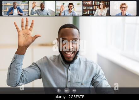 Communication. Laptop webcam screen view of multiethnic men and women contacting distantly by videoconference. Smiling diverse employees making video Stock Photo