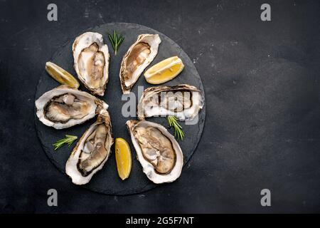 Oysters with lemon on platter Stock Photo