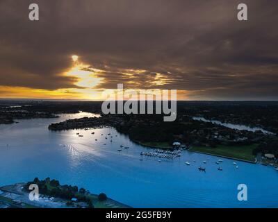 Panorama drone aerial view over Sydney harbour on a cloudy sunset afternoon showing the nice colours of the harbour foreshore Stock Photo