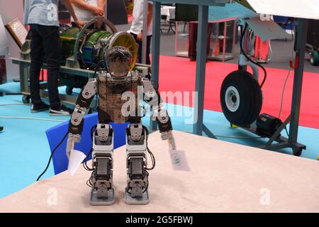 Small human-shaped robot holding banners at exhibition of an industrial fair Stock Photo