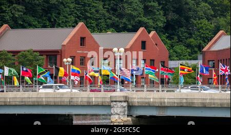 WESTPORT, CT, USA - JUNE 26, 2021:  Flags waving on bridge over Saugatuck river in nice cloudy day Stock Photo