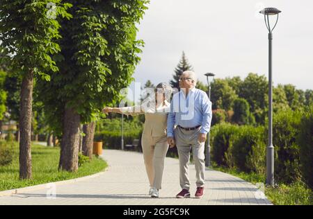 Healthy active senior old couple walking in park talking enjoy time together Stock Photo