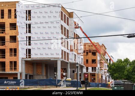 GREENVILLE, SC, USA-23 JUNE 2021: New construction showing wood framing and workers on skylifts. Stock Photo