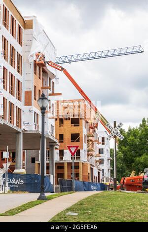 GREENVILLE, SC, USA-23 JUNE 2021: New construction showing wood framing and workers on skylifts. Stock Photo