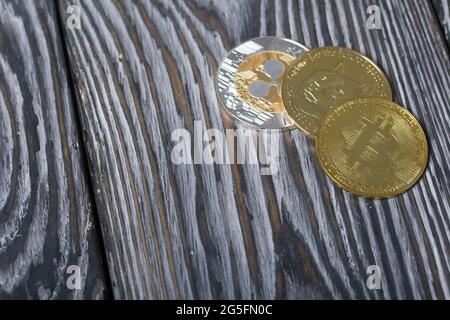 Coins of various cryptocurrencies. On brushed pine boards. Stock Photo