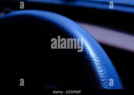 Abstract macro photography, close up leather texture car steer wheel with blue light Stock Photo