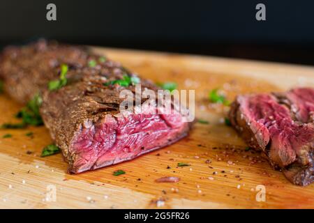 Tequila Lime Marinated Hanger Steak: Rare butcher's steak on a bamboo cutting board Stock Photo