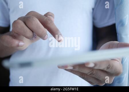 young man in casual white dress using digital tablet on office desk  Stock Photo