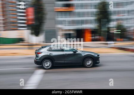 Ukraine, Kyiv - 29 April 2021: Gray MAZDA CX-30 car moving on the street. Editorial Stock Photo