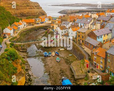 View looking seawards over the harbour of the North Yorkshire Village of Staithes with Cowbar on the North side of Roxby Beck Stock Photo