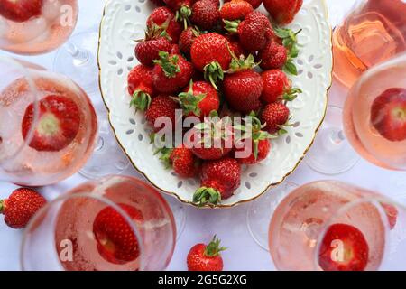 Creative composition with rose wine and delicious strawberries on the white background, top view Stock Photo