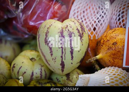 Heart-shaped fruit, native to South America, is called pepino dulce - sweet cucumber - or even just pear melon. Stock Photo