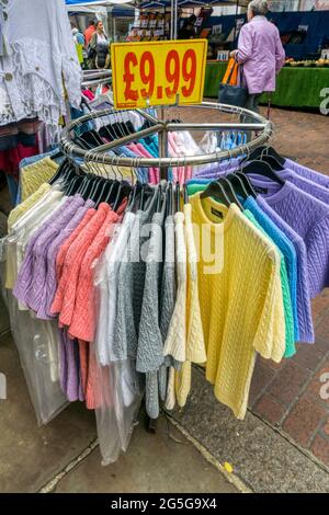 Rail of women's clothes for sale on a stall in a street market. Stock Photo