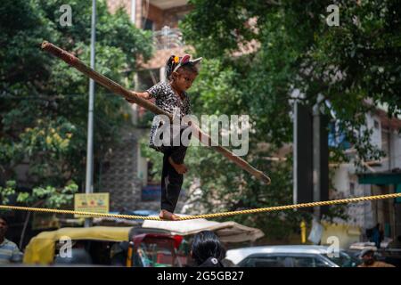 New Delhi, India. 27th June, 2021. An unidentified Indian girl does street acrobatics by walking on a rope in a performance to earn a livelihood. Credit: SOPA Images Limited/Alamy Live News Stock Photo