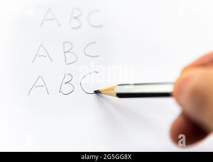 A person writing the alphabet with a pencil. Earning learning concept. Stock Photo