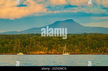 setting sun on Lake Champlain lighting up Camel's Hump in the background Stock Photo