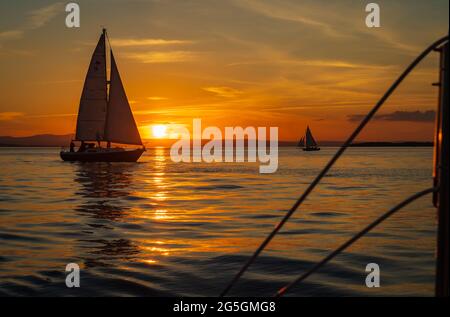 setting sun on Lake Champlain enjoyed by sail boats Stock Photo