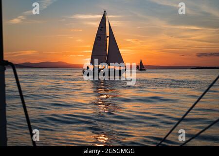 setting sun on Lake Champlain enjoyed by sail boats Stock Photo