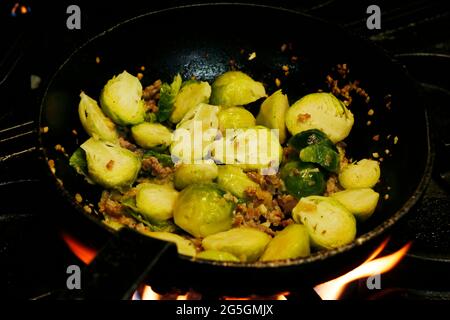 brussels sprouts cooking in a saute pan on fire Stock Photo