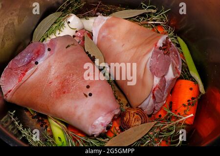 preparation of pork knuckle with aromatic herbs and spices roasted flavoured vegetables Stock Photo