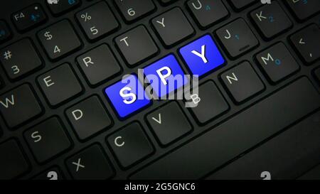 a SPY text on three blue keys on a black laptop keyboard background - technology protection concept Stock Photo