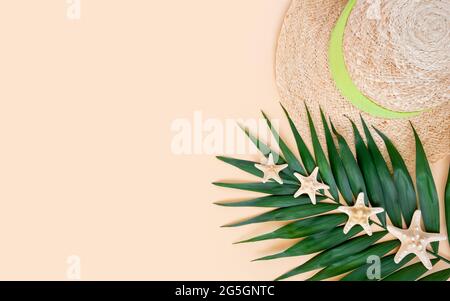 Palm leaf, straw hat and starfish on a blue wooden background, top view ...