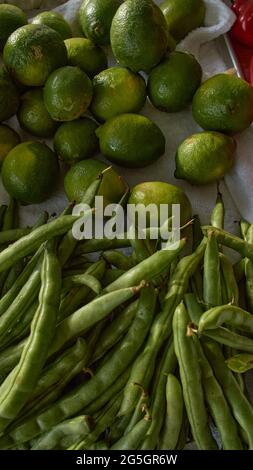 Lemons and green peas washed in warm dim light Latin kitchen ready for cutting Stock Photo