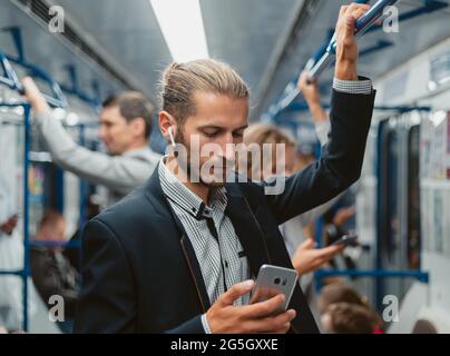 young man reading his correspondence in the subway . Stock Photo