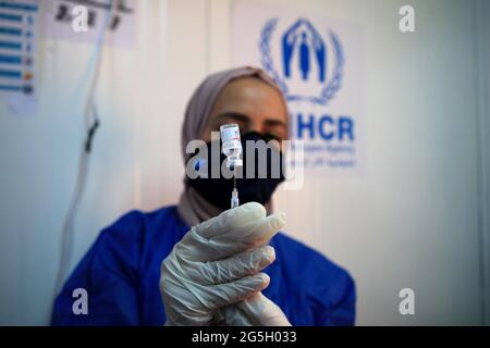 Zaatari, Jordan. 27th June, 2021. A medical worker prepares a dose of the COVID-19 vaccine at a medical center in the Zaatari refugee camp in Zaatari, Jordan, on June 27, 2021. Out of about 29,000 refugees who are eligible for the COVID-19 vaccine living in Zaatari refugee camp, some 45% of them have received at least their first dose of the vaccine until now, the UN Refugee Agency (UNHCR) Jordan told Xinhua on Sunday. Credit: Mohammad Abu Ghosh/Xinhua/Alamy Live News Stock Photo