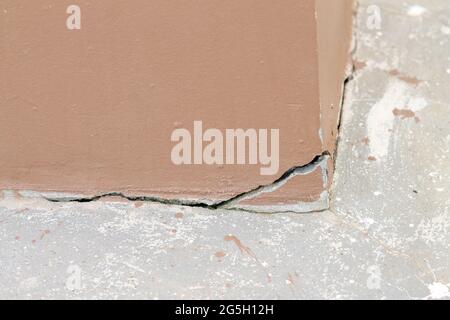Deep cracks and holes in the exterior concrete wall old brown wall damaged Move or crack concrete. Copy space. Stock Photo