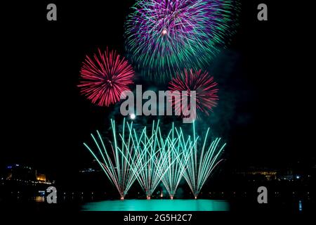 Colourful firework display over downtown fills the night sky Stock Photo
