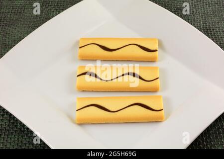 Macarpone cream filled cookies with chocolate on white dessert plate Stock Photo