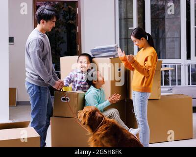 A happy family of four and their pet dog are playing in the room high quality photo Stock Photo