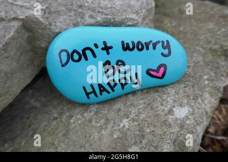 Don't worry be happy and valentine heart painted on kindness rock Stock Photo