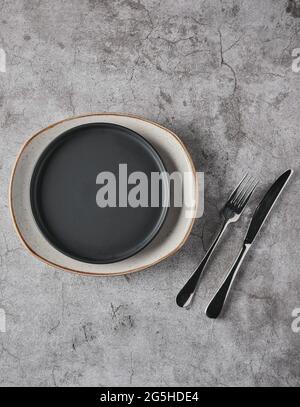Empty plates, forks on grey concrete background. Top view. Concept mockup Stock Photo