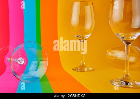 Empty cristal glass of wine on colors background. Concept lgbt Stock Photo