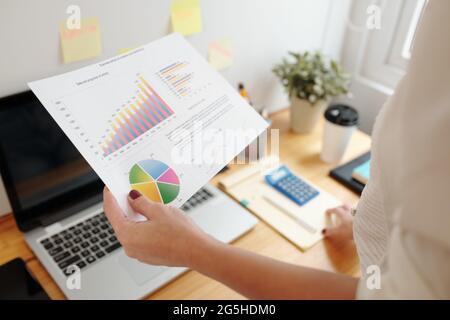 Close-up image businesswoman analyzing sales report with charts and diagrams to draw conclusions about business development Stock Photo