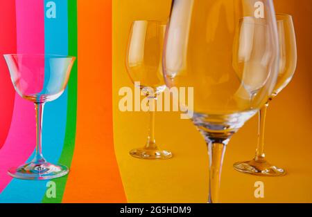 Empty cristal glass of wine on colors background. Concept lgbt Stock Photo