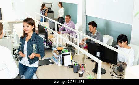 Male and female office co-workers having conversation at desk in office Stock Photo