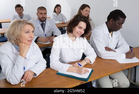 People in white coats in boardroom Stock Photo