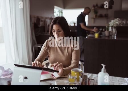 Female entrepreneur working on digital tablet at home Stock Photo