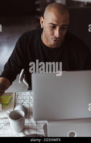 Male entrepreneur working on laptop from home Stock Photo